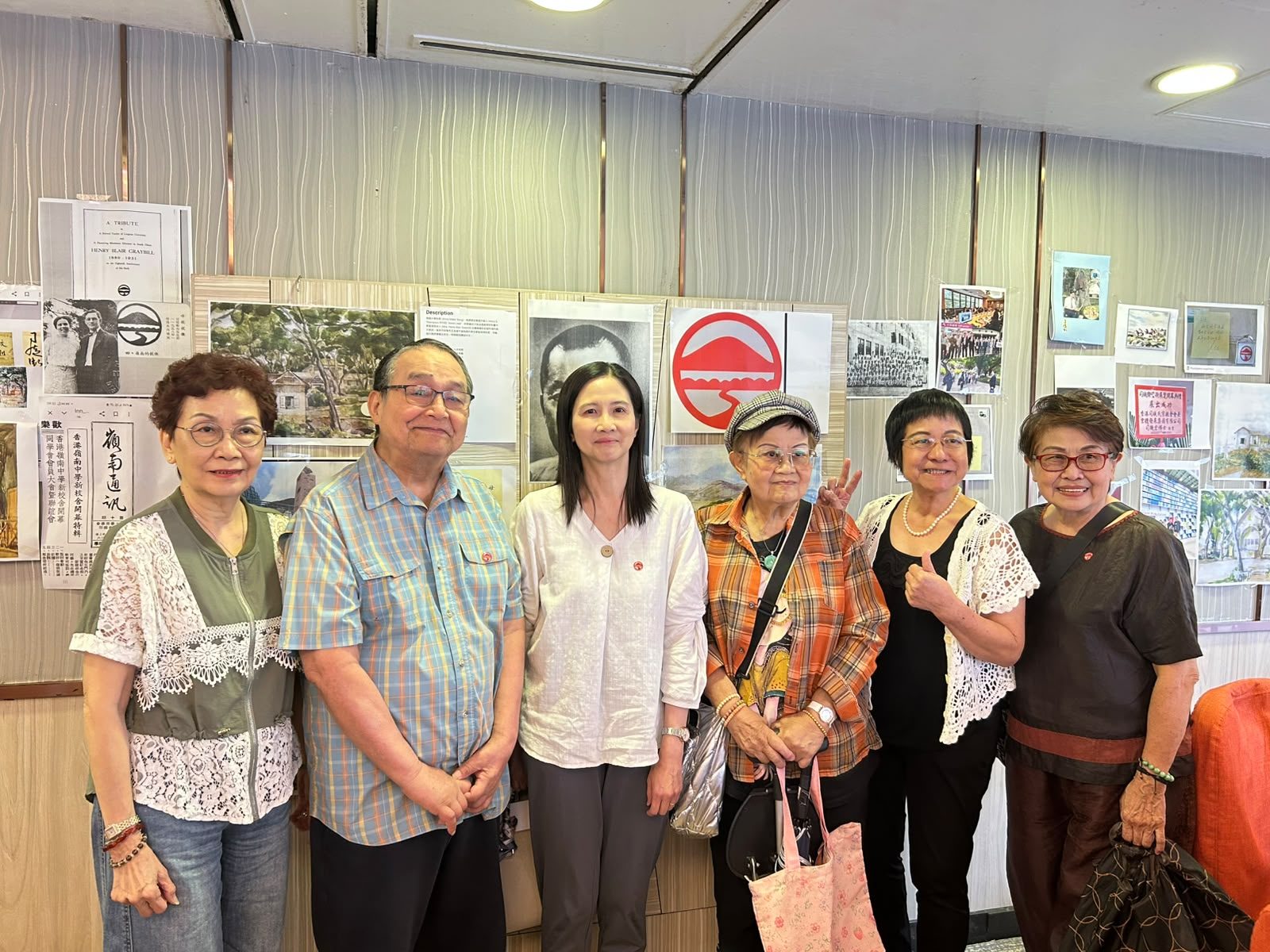 鋿晶館內，校友於海報展示前合影。