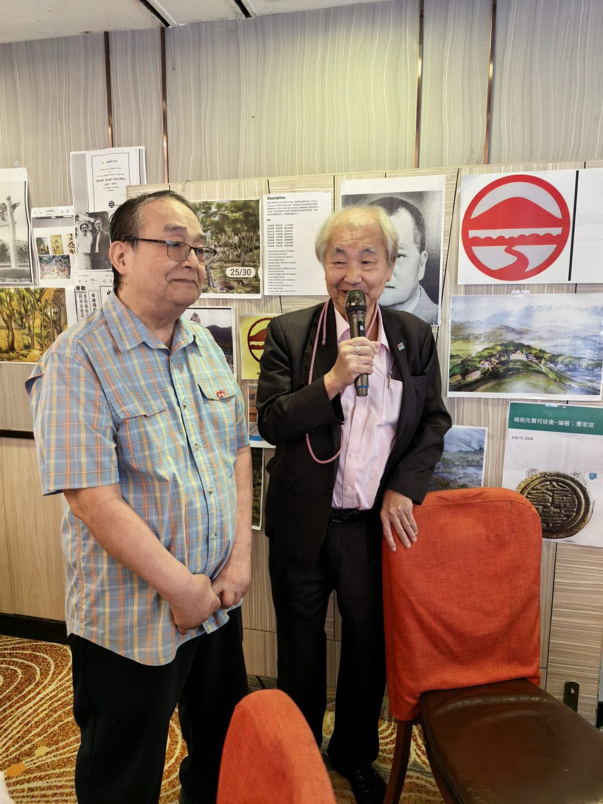 展品之前發言；牆上為李應林校長像與嶺南校歌，右下展板為「嶺南先賢司徒衞～編著：曹家道」。