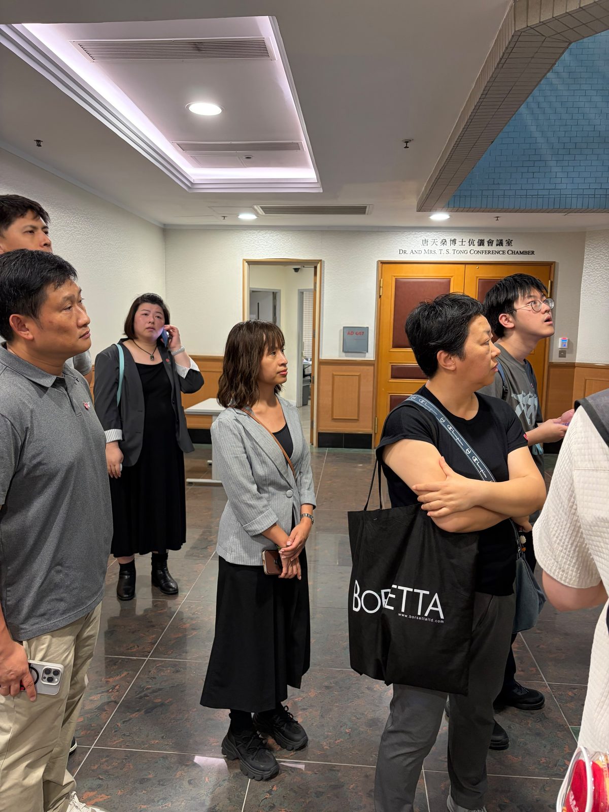 會議室外候入，門旁鐫「唐天燊博士伉儷會議室」。
